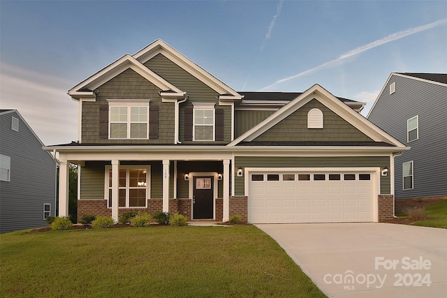 craftsman-style home featuring an attached garage, covered porch, brick siding, concrete driveway, and a front lawn