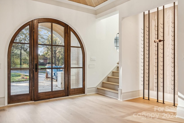 entrance foyer featuring light wood-type flooring, crown molding, and french doors