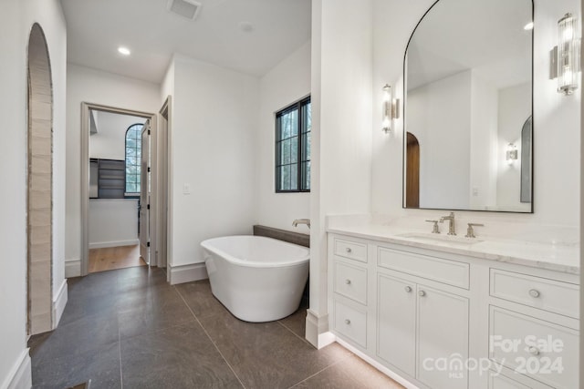 bathroom featuring a washtub, vanity, and tile patterned flooring