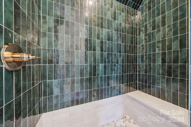 bathroom featuring tiled shower and tile walls