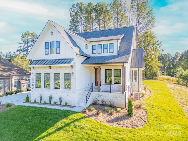 modern farmhouse style home with a front lawn and a porch