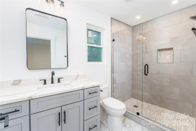 bathroom featuring vanity, an enclosed shower, and toilet