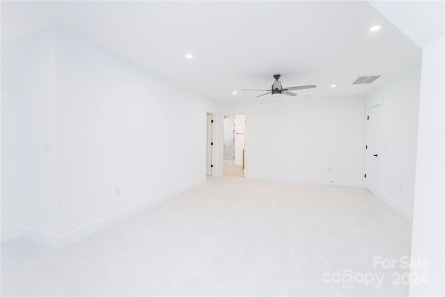 spare room with ceiling fan and light colored carpet