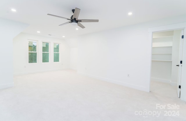 carpeted empty room with vaulted ceiling and ceiling fan