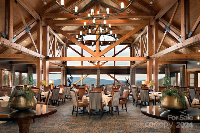 dining space with beam ceiling, a mountain view, carpet flooring, and a chandelier