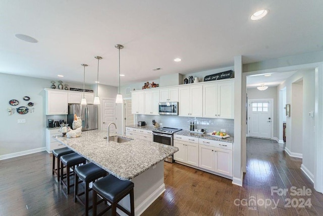 kitchen featuring pendant lighting, sink, white cabinetry, a kitchen island with sink, and stainless steel appliances