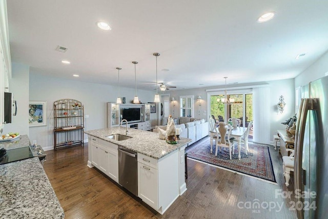 kitchen with a center island with sink, sink, stainless steel appliances, white cabinets, and light stone counters