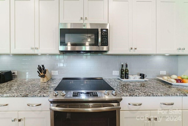 kitchen featuring backsplash, white cabinets, and stainless steel appliances