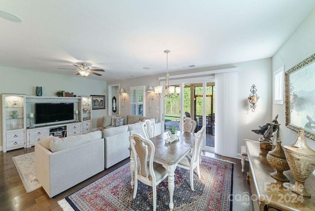 dining area with dark hardwood / wood-style flooring, a wealth of natural light, and ceiling fan with notable chandelier