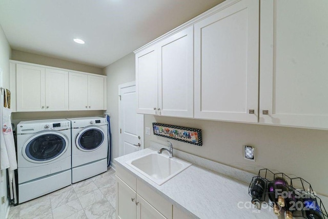 laundry room with washer and clothes dryer, sink, and cabinets