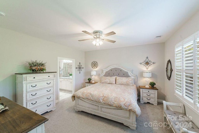 bedroom featuring ceiling fan, connected bathroom, and light carpet