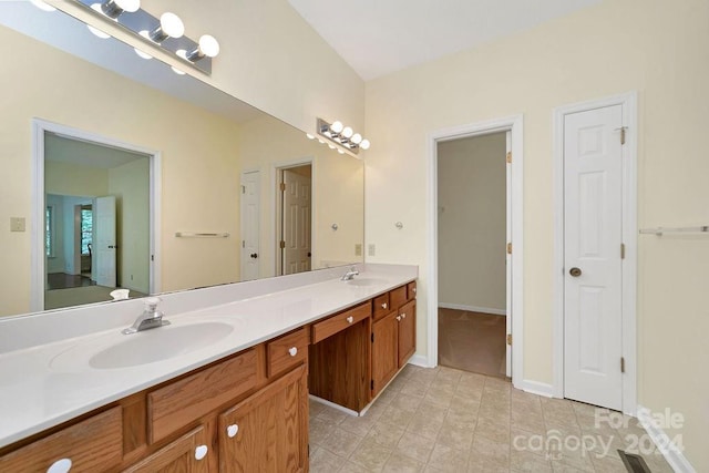 bathroom featuring vanity with extensive cabinet space, double sink, and tile floors