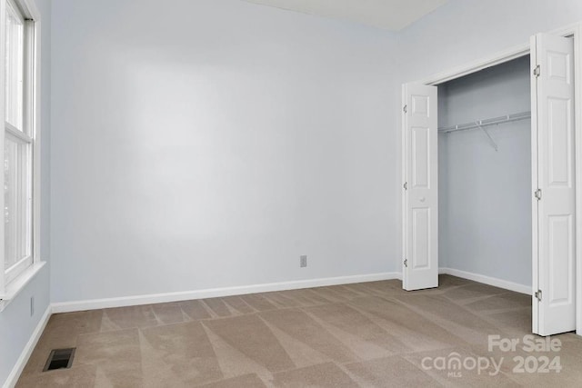 unfurnished bedroom with a closet and carpet floors