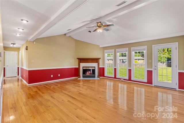 unfurnished living room with plenty of natural light, light hardwood / wood-style flooring, lofted ceiling with beams, and ceiling fan