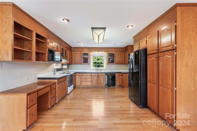 kitchen featuring light hardwood / wood-style flooring, sink, and black appliances