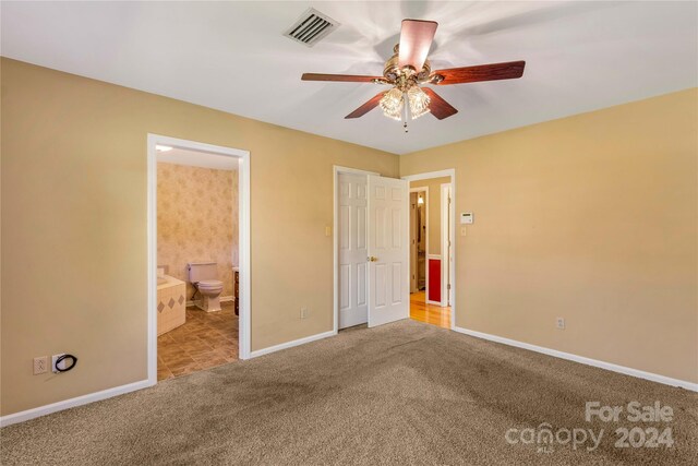 unfurnished bedroom featuring ceiling fan, carpet flooring, and ensuite bathroom