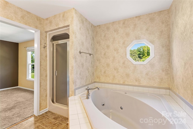 bathroom featuring shower with separate bathtub and tile floors