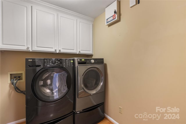 washroom featuring cabinets and washing machine and clothes dryer