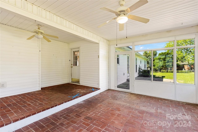 unfurnished sunroom featuring ceiling fan