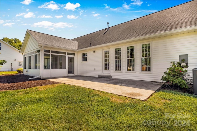 rear view of property featuring a patio, a sunroom, and a lawn