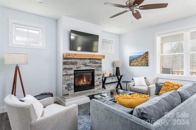 living room featuring ceiling fan and a fireplace