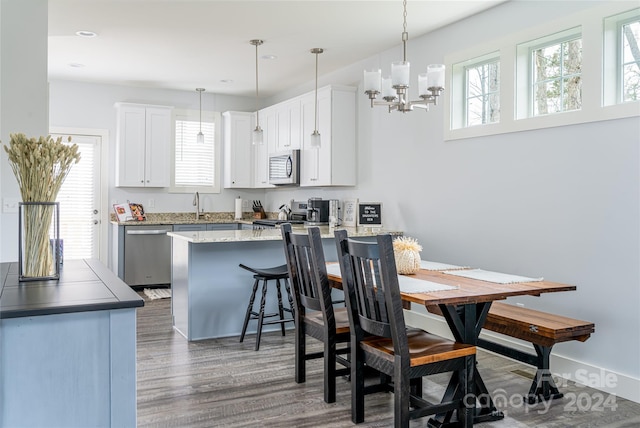 dining area featuring sink, dark hardwood / wood-style floors, and an inviting chandelier