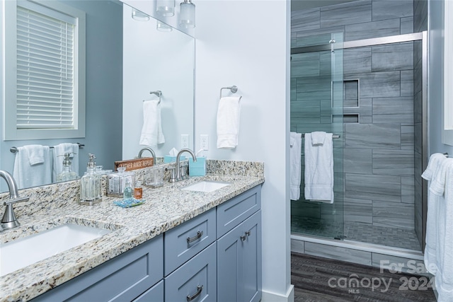 bathroom featuring hardwood / wood-style floors, double sink vanity, and an enclosed shower