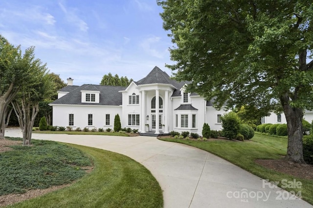 french country inspired facade with a front lawn