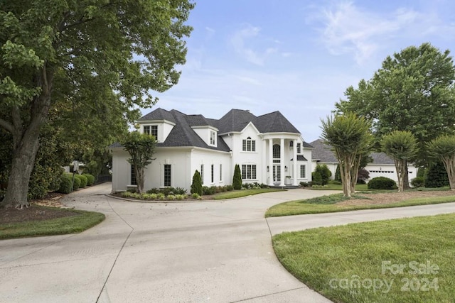 french country inspired facade with a garage and a front yard