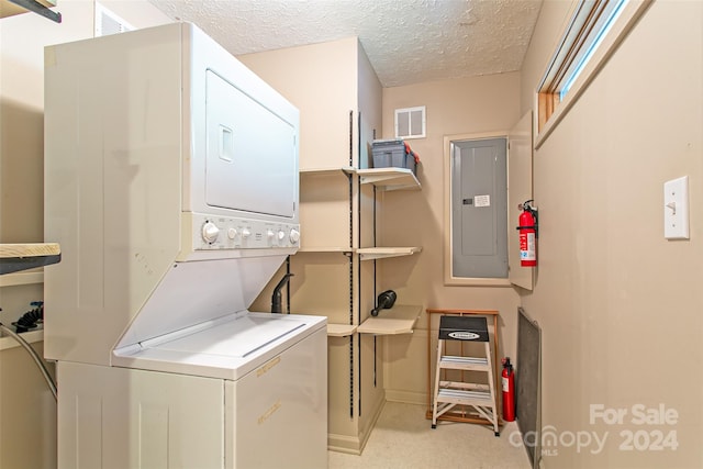 laundry room featuring light colored carpet, stacked washer / dryer, hookup for a washing machine, and a textured ceiling