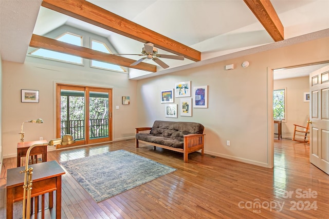 living room with hardwood / wood-style floors, ceiling fan, and vaulted ceiling with beams