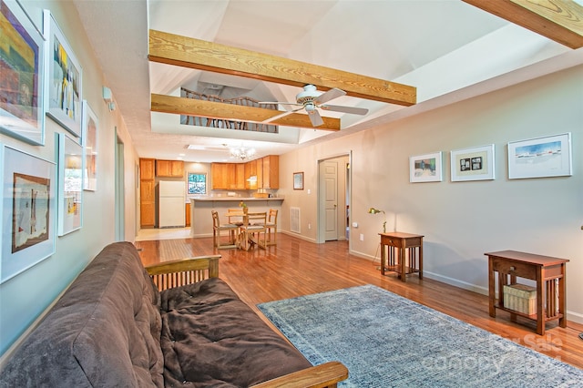 living room with beamed ceiling, hardwood / wood-style floors, and ceiling fan