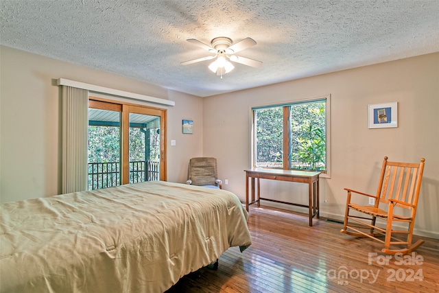 bedroom with a textured ceiling, hardwood / wood-style floors, ceiling fan, and access to outside