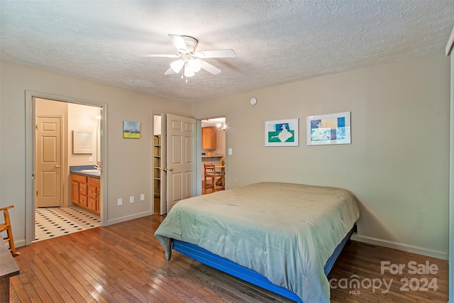 bedroom with ceiling fan, wood-type flooring, a textured ceiling, sink, and connected bathroom