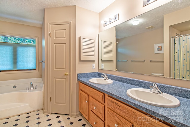 bathroom featuring tile flooring, vanity with extensive cabinet space, a washtub, a textured ceiling, and double sink