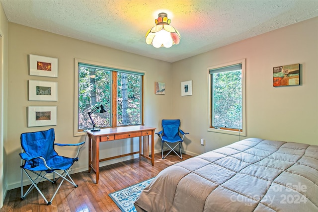 bedroom with hardwood / wood-style floors and a textured ceiling