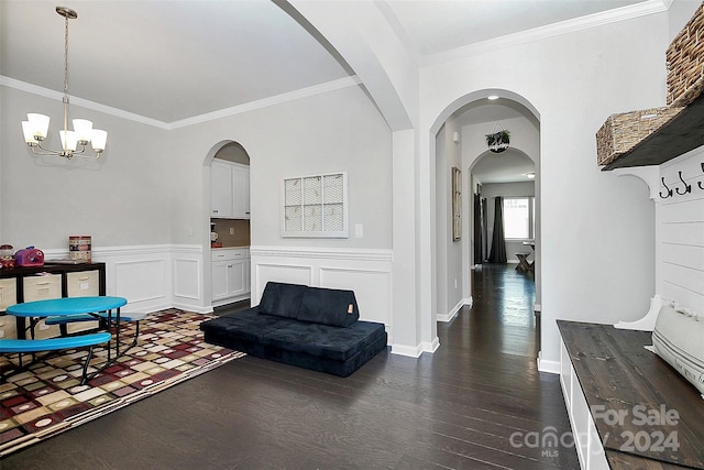 living room featuring dark wood-type flooring, a chandelier, and ornamental molding