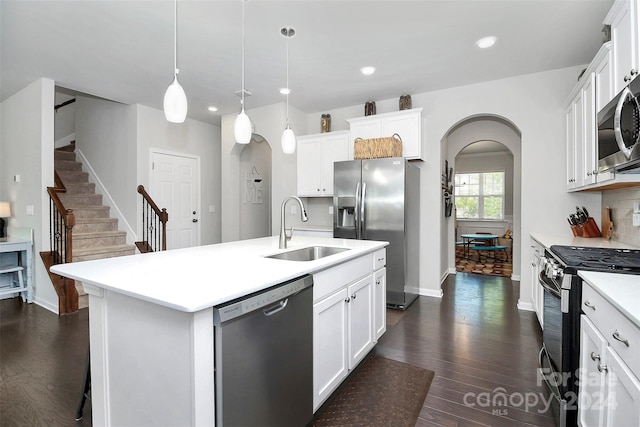 kitchen with a kitchen island with sink, white cabinetry, stainless steel appliances, and dark hardwood / wood-style floors