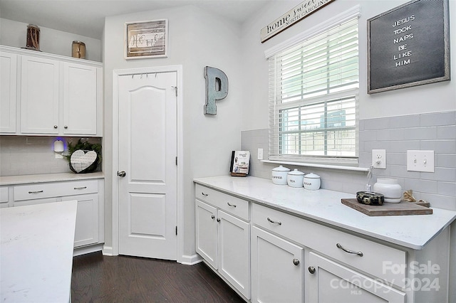 kitchen with white cabinets, tasteful backsplash, dark hardwood / wood-style flooring, and light stone counters