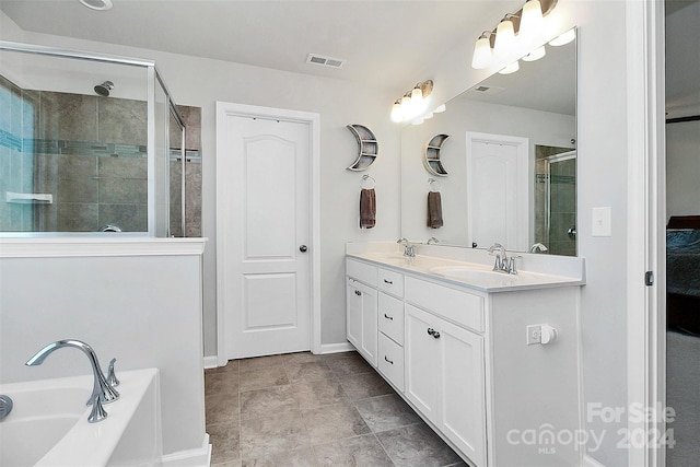 bathroom featuring tile flooring, independent shower and bath, and dual vanity