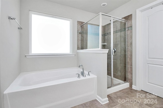 bathroom featuring plenty of natural light, tile floors, and separate shower and tub