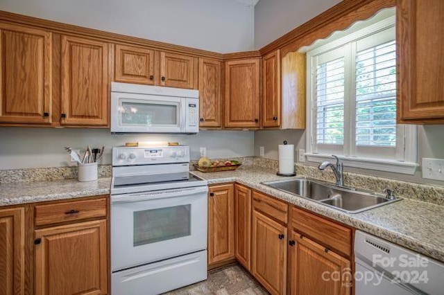 kitchen featuring white appliances, sink, and light tile flooring