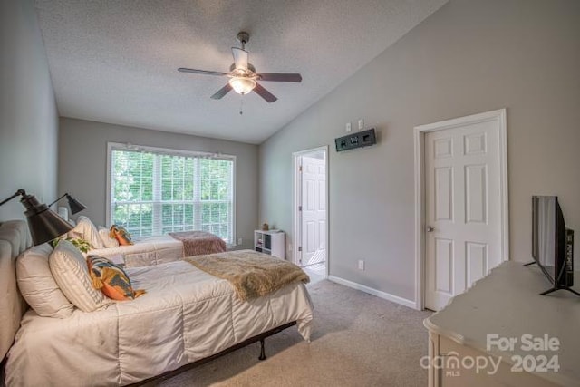 bedroom with lofted ceiling, ceiling fan, a textured ceiling, and carpet flooring