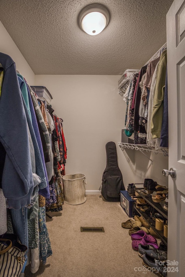 walk in closet featuring carpet flooring