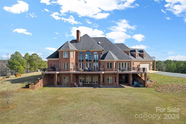 rear view of house with a patio, a lawn, and a balcony