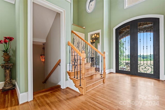 entrance foyer featuring french doors, high vaulted ceiling, and light wood-type flooring