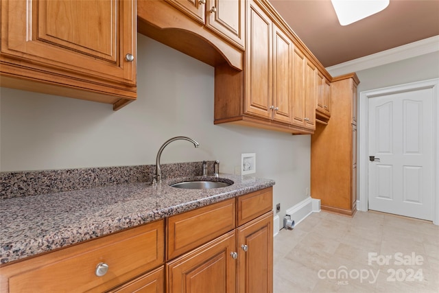 washroom featuring sink, crown molding, washer hookup, and cabinets