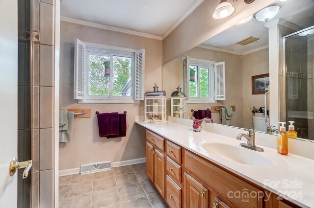 bathroom with an enclosed shower, tile patterned floors, toilet, vanity, and ornamental molding