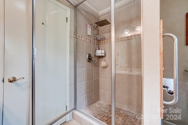 bathroom with an enclosed shower and crown molding