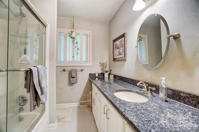 bathroom featuring vanity, tile patterned floors, and bath / shower combo with glass door